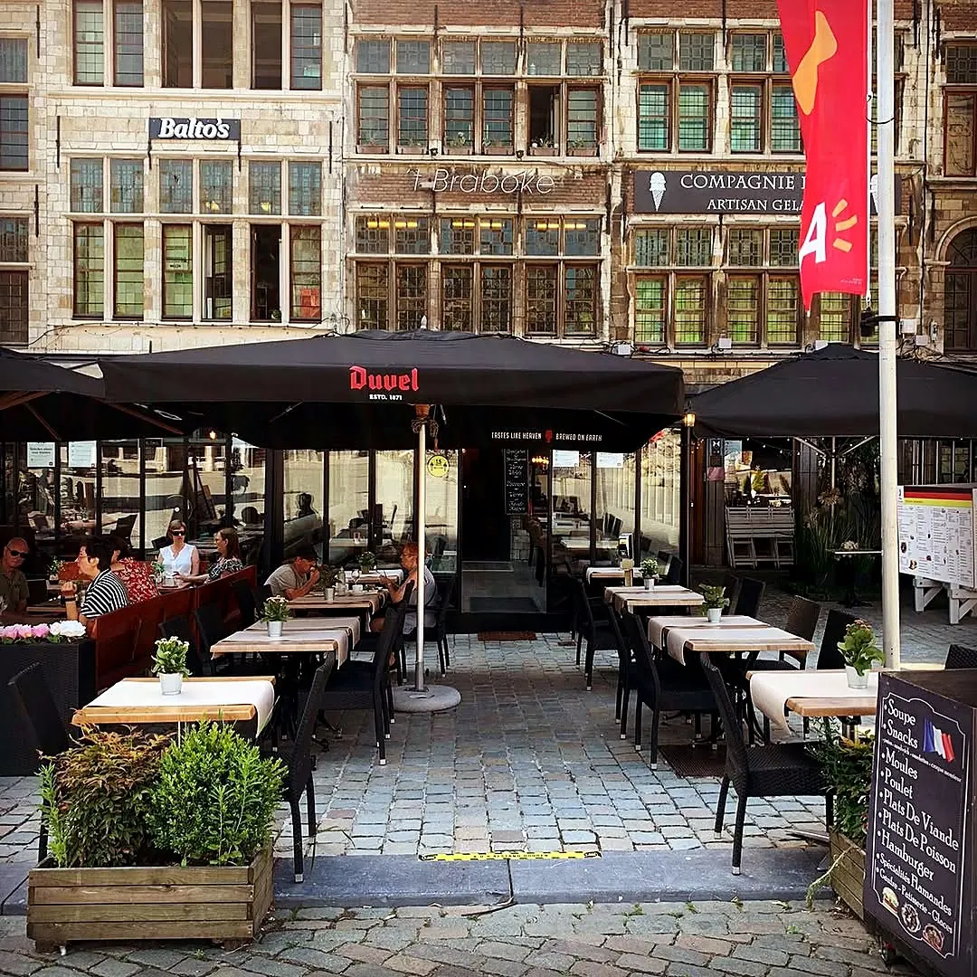 The terrace of 't Braboke under the parasols, in front of the guild houses of the Grote Markt